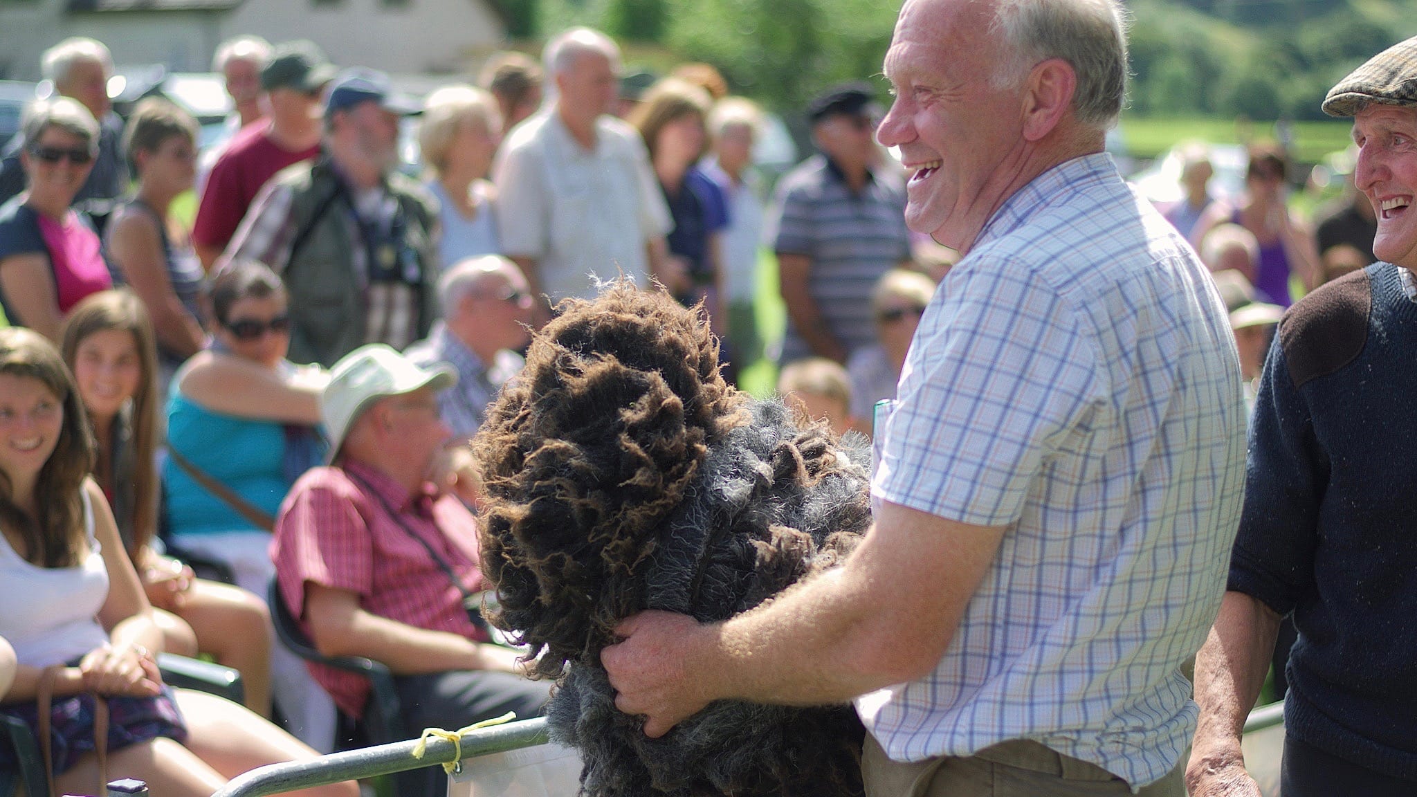 A farmer at a cumbrian county show holding some Herdwick fleece