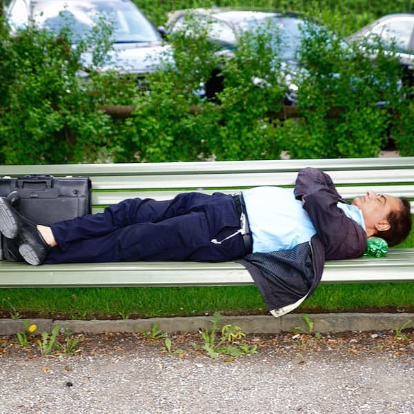 a man asleep on a park bench