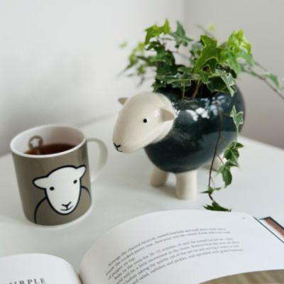 a grey Herdy planter with English Ivy planted inside, alongside a grey herdy mug